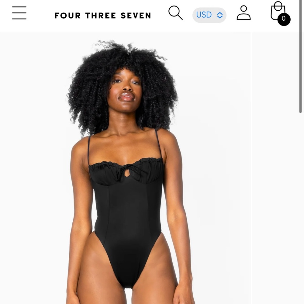 Black one-piece, hygiene sticker still on. Never worn.
